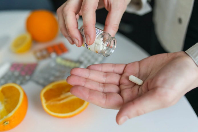 person holding a supplement capsule