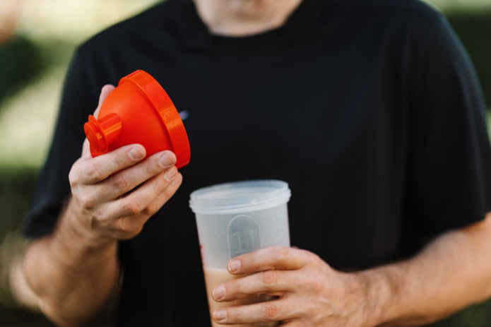 man holding protein shaker